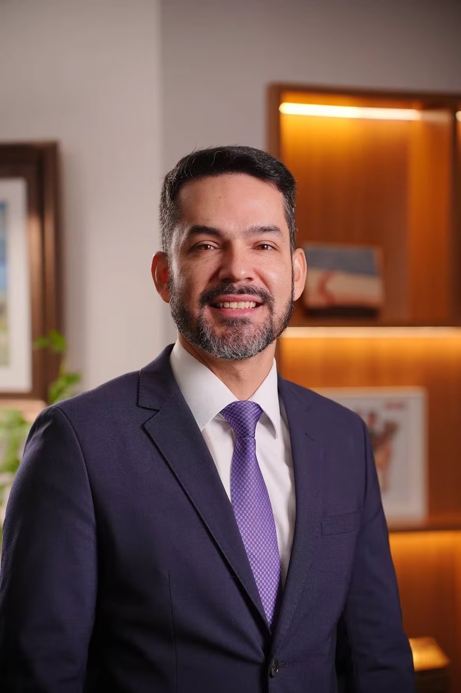 Retrato de Alexander Andrade Leite em seu escritório, de terno azul-marinho